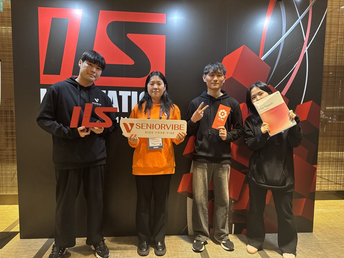 Innovation Leaders Summit 2025の会場で、シニアバイブのプレートとVibe Reportを持つチームメンバー